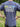 Person wearing a blue t-shirt with 'Great Outdoor Provision Co.' text and graphics outdoors.