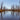 A swamp with yellow grass, dark water, and tall trees 