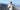 A man with a backpack and hat at a vista at the top of a mountain