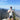 A man with a backpack and hat at a vista at the top of a mountain